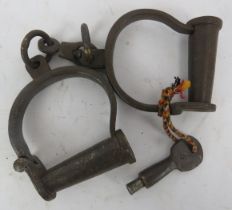 A pair of cast iron handcuff shackles, probably 19th century. Condition report: Some wear with age.