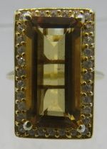 A silver gilt faceted elongated citrine cocktail ring, edged with white stones. Overall setting 23mm