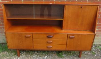 A mid-century teak sideboard, housing a glazed display shelf and fall-front bureau section, above