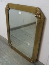 An Arts & Crafts wall mirror, the bevelled plate within a planished and riveted brass frame with