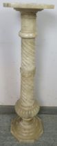 A vintage alabaster torchere, the spiral carved tapering column with Greek key detail, on a