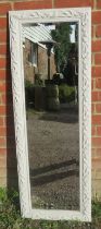 A contemporary bevelled dressing mirror, in an acanthus moulded frame painted white. H131cm W46cm (