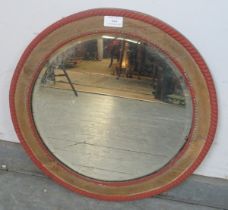 A turn of the century circular bevelled wall mirror, within a stripped oak frame with beaded red