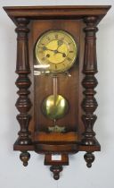 An Edwardian mahogany 8-day wall clock, the gilt brass dial flanked by reeded and turned