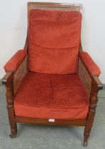 A 19th century mahogany and bergère library chair, with loose cushions upholstered in crimson