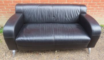 A contemporary two-seater sofa in the 1970s style, upholstered in black leather, on cast aluminium