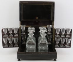 An ebonised wood tantalus drinks decanter box with glassware, 19th century. With brass strung