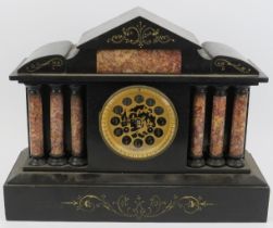 A Victorian black slate and marble mantel clock. The case featuring Tuscan columns in marble with