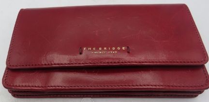 The Bridge red leather purse, boxed. Condition report: Some scratching.