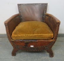 An early 20th century French armchair, upholstered in distressed brown leather with brass stud