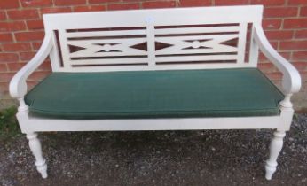 A George III style white painted garden bench, 20th Century, with green squab cushion, 132cm wide.