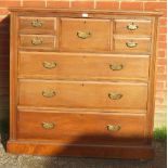 A turn of the century walnut bedroom chest, the central hat drawer flanked by four short drawers,