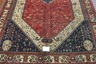 South West Persian Abadeh carpet central motif blue on red ground. The motif repeated in the blue