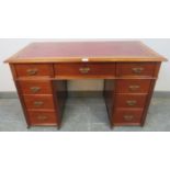 An Edwardian mahogany child's pedestal desk, inset red leather top above configuration of 9