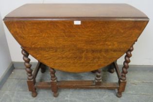 An antique oak oval gate-leg table of small proportions, on barley twist supports with stretchers.