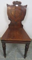 A 19th century mahogany hall chair, the shield back with acanthus carved details, on tulip carved