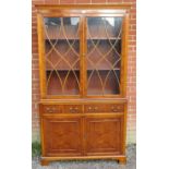 A reproduction yew wood tall glazed bookcase, having tracery doors opening onto two height-