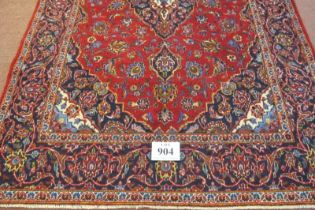 A fine central Persian Kashan rug central motif on a deep red ground with indigo spandriels and deep