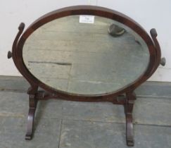 An Edwardian mahogany oval swing dressing table mirror on splayed supports. W49cm (approx).