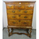An antique cross-banded walnut chest on stand in the Queen Anne style, the swept moulded cornice