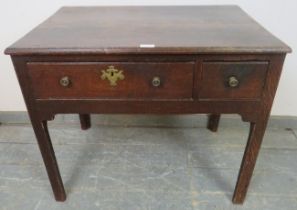 An 18th century oak lowboy with one long drawer, raised on inner chamfered legs, some repairs and