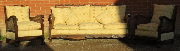 A vintage early/mid 20th century Bergere three piece lounge suite, comprising a three seater settee,