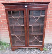 A George III mahogany enclosed bookcase, having a dentil cornice above astral glazed doors,