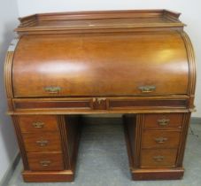 A 19th century roll top desk, having 3/4 gallery top above the revolving cylinder enclosing