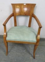 An Empire style fruitwood open-sided armchair, upholstered seat.