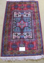 A late 20th century Persian rug with central block panel in good condition. 137cm x 78cm overall.