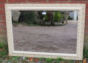 A period-style cream finished wall mirror with relief moulded decoration. 90cm x 65m (approx).