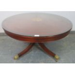 A reproduction mahogany circular coffee table, crossbanded and having central marquetry inlaid