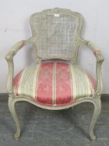 A reproduction French open-sided armchair in the Louis XV taste, painted grey and distressed, having