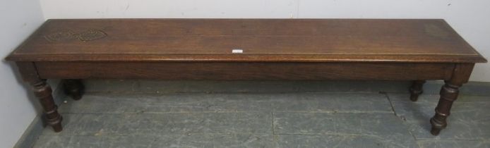 An unusually long 19th century oak hall bench/window seat, carved decoration to one end of seat,