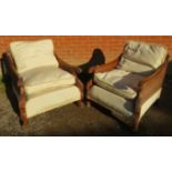 A pair of early/mid 20th century Bergere armchairs, having ornately carved show-wood frames,