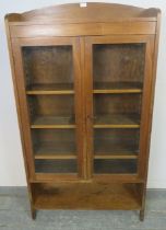 A turn of the century walnut glazed bookcase, housing three height adjustable shelves above an