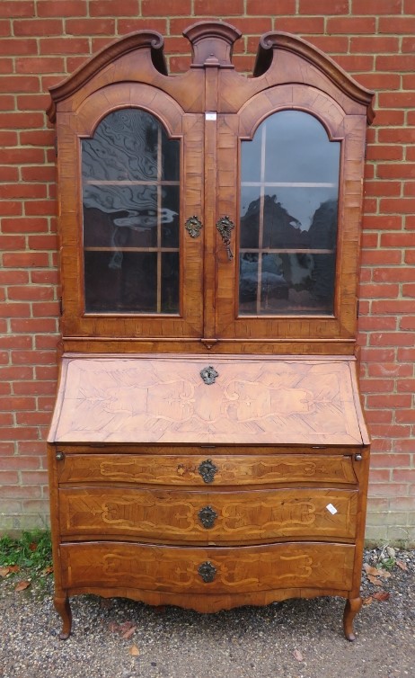 A large 18th century Continental marquetry bureau bookcase, having a broken and scrolled pediment