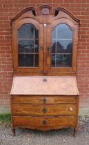A large 18th century Continental marquetry bureau bookcase, having a broken and scrolled pediment