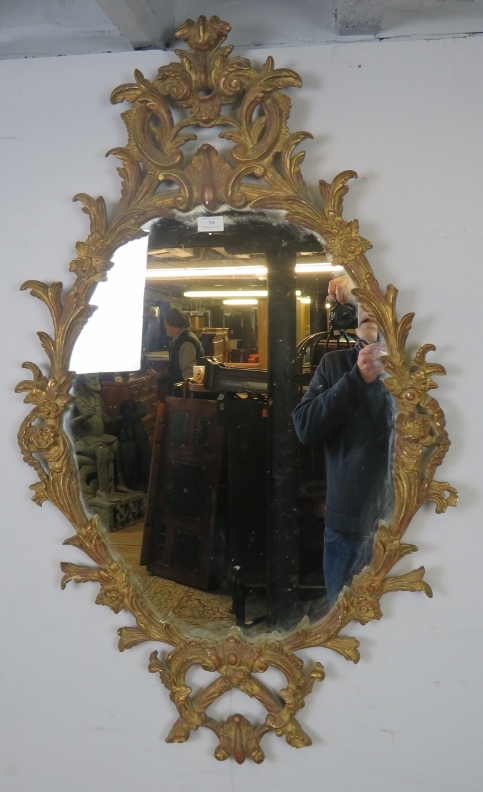 A highly decorative Georgian revival carved giltwood wall mirror, 20th century, decorated with