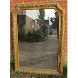 A large 19th century French giltwood wall mirror, of rectangular form with swept inverted top