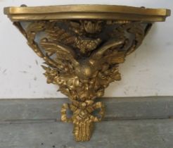 A Victorian gilt gesso & giltwood wall bracket, modelled in bold relief with a bird, flowers,