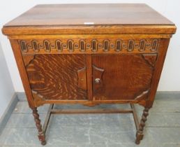 A 1920s oak cased floor-standing gramophone by Atlas, on barley twist supports with an ‘H’