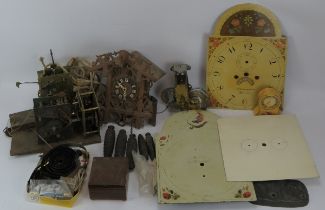 An assortment of antique clock parts including dials, movements. (Quantity - A/F - Viewing