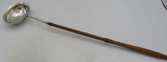 An unmarked white metal toddy spoon with fruitwood handle, 19th century. Condition report: Slight
