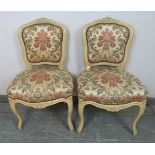 A pair of vintage French side chairs in the Louis XV style, cream painted carved wood frames,