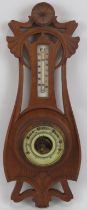 An Art Nouveau carved oak barometer, early 20th century. Incorporated with a mercury thermometer.