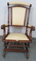 An early 20th century American mahogany ‘Dexter’ rocking chair, re-upholstered in cream leather with