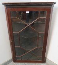 A Georgian mahogany glazed corner cupboard, with dentil cornice, the astral glazed door opening onto