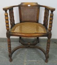 An antique fruitwood Continental bergère tub chair, the curved arms joined by shaped spindles and