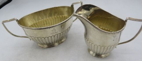 A Victorian silver cream jug and sugar bowl with half fluting decoration, London 1883, Goldsmiths